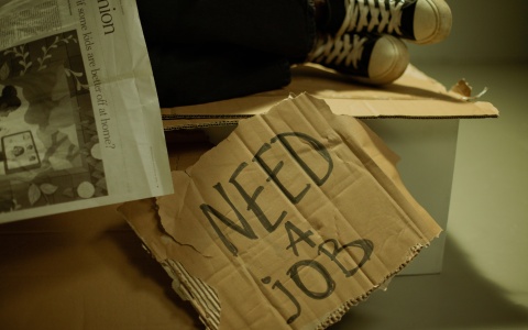 Schild mit der Aufschrift "Need a Job" als Symbol für Arbeitslosigkeit