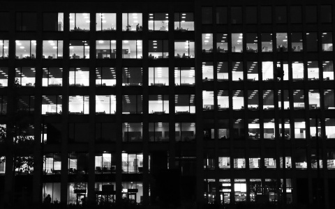 Bürogebäude mit beleuchteten Fenstern als Symbolbild für die Arbeitsmarktreform-Arbeitslosigkeit-Arbeitslosengeld