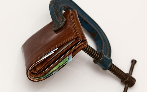 Das Bild zeigt ein Geldbörsel in einer Schraubzwinge. Es verbildlicht damit die Teuerung, die für Haushalte mit niedrigen Einkommen ein Problem ist. Die Regierung hat ein Entlastungspaket geschnürt. 
