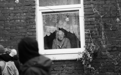 Alte Frau schaut aus dem Fenster – Symbolbild für den Equal Pension Day