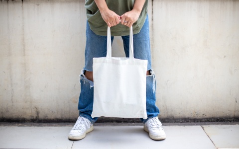 Mensch mit weißer Stofftasche als Symbolbild dafür, dass Lohnerhöhungen den Konsum stärken