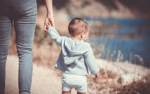 Frau mit Kind an der Hand als Symbolbild für den Gender Pay Gap, für den Mutterschaft nur eine untergeordnete Rolle spielt. 