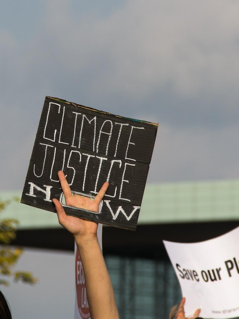 Das Bild zeigt einen Demonstranten mit einem Schild auf dem "Climate Justice" steht. Dafür wäre ein Lückenschluss bei der CO2-Steuer wichtig.