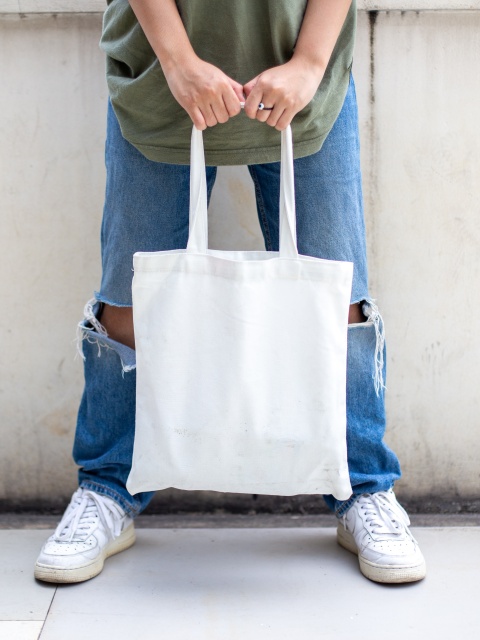 Mensch mit weißer Stofftasche als Symbolbild dafür, dass Lohnerhöhungen den Konsum stärken